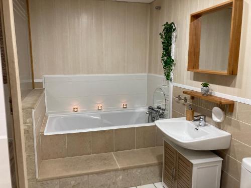 ein Badezimmer mit einer Badewanne und einem Waschbecken in der Unterkunft Gîte Doumenc in Thierville-sur-Meuse