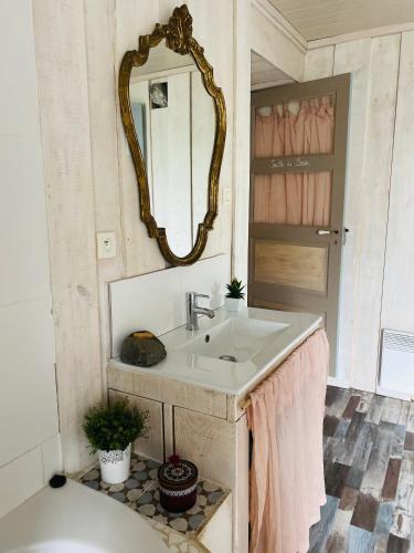 une salle de bain avec un lavabo et un miroir dans l'établissement La Poterie, à Carresse