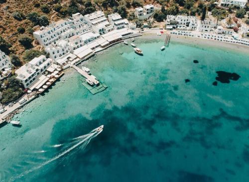 a boat in the water next to a beach at Stone villa Halepa panoramic view, private pool,big garden & quiet in Néon Khoríon