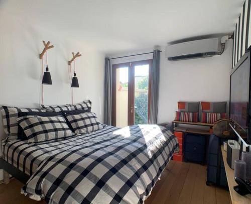 um quarto com uma cama em preto e branco e uma janela em Appartement avec Jacuzzi - Climatisation - Parking em Bordeaux