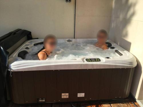 dos bebés en un jacuzzi en una bañera en Appartement avec Jacuzzi - Climatisation - Parking en Burdeos