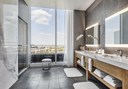 a bathroom with two sinks and a large window at Live! by Loews - Arlington, TX in Arlington
