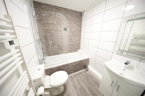 a white bathroom with a toilet and a sink at Wellington House in Hull