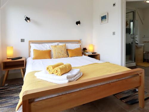 een slaapkamer met een groot bed en handdoeken bij The Cowshed in Merrymeet