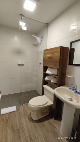 a bathroom with a toilet and a sink and a shower at Apart Cayambe in Cayambe