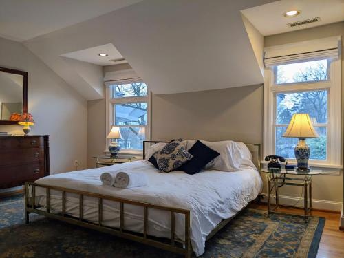 a bedroom with a large bed with two windows at Stanton House Inn in Greenwich