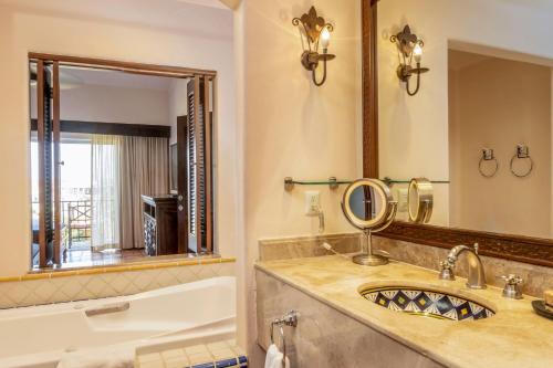 a bathroom with a tub and a sink and a mirror at Hacienda del Mar Los Cabos, Autograph Collection in Cabo San Lucas