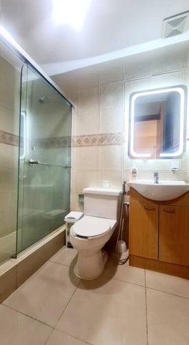 a bathroom with a toilet and a shower and a sink at Suite Torre Sol OmniHospital Torre Médica in Guayaquil