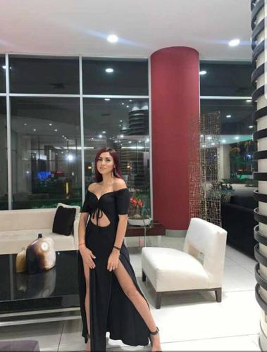 a woman in a black dress standing in a room at Suite Torre Sol OmniHospital Torre Médica in Guayaquil
