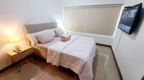 a small bedroom with a bed and a window at Suite Torre Sol OmniHospital Torre Médica in Guayaquil