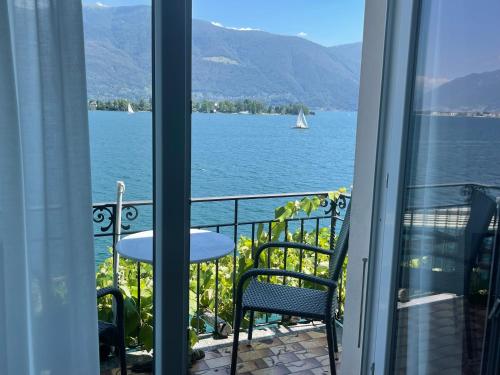 a balcony with a view of the water and a sailboat at Art Hotel Ristorante Posta Al Lago in Ronco s/Ascona - Porto Ronco