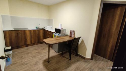 a room with a desk with a microwave and a kitchen at Apart Cayambe in Cayambe