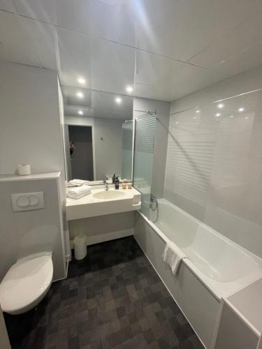La salle de bains est pourvue de toilettes, d'un lavabo et d'une baignoire. dans l'établissement KYRIAD DIRECT LYON NORD - Dardilly, à Dardilly