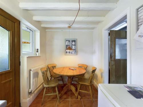 comedor con mesa de madera y sillas en Two Bedroomed House near Newark & Grantham 