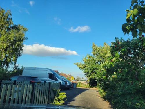 a row of parked cars parked next to a fence at Two Bedroomed House near Newark & Grantham in Foston