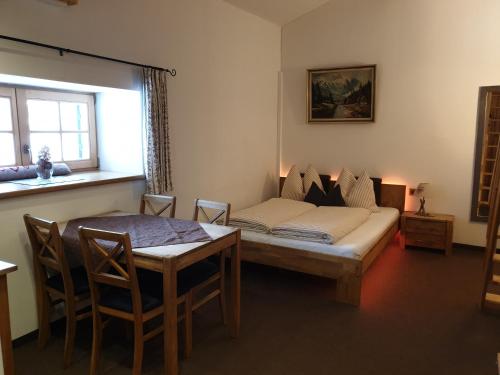 a living room with a bed and a table and a window at Gut Unterbrunn in Radstadt