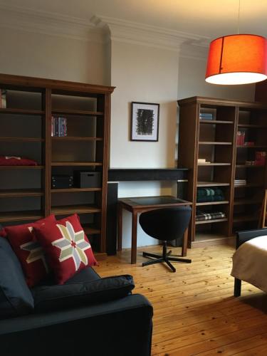 ein Wohnzimmer mit einem Sofa und einem Schreibtisch in der Unterkunft Overijse’s cosiest double room in Overijse