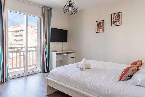 une chambre avec un grand lit blanc et un balcon dans l'établissement Villa la plage, à Arcachon