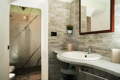 La salle de bains est pourvue d'un lavabo et d'un miroir. dans l'établissement B & B Agrigento antica, à Agrigente