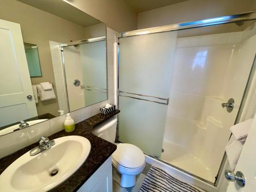 a bathroom with a shower and a sink and a toilet at Mountain Chalet at Mystic Springs, 2BR, 2BA, Heated Pool, Hot Tub! in Canmore