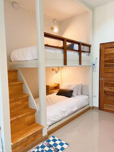 1 dormitorio con 2 literas y escalera en Teenan Hostel, en Nan