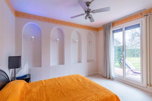 1 dormitorio con cama de color naranja y ventana en Chez Laurent en Épagny