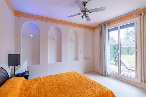 - une chambre avec un lit orange et une fenêtre dans l'établissement Chez Laurent, à Épagny