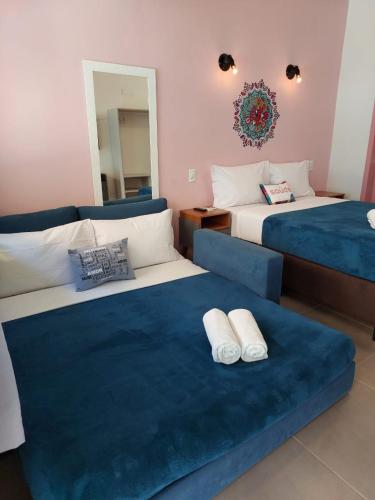 a bedroom with two beds and a blue couch at Pousada Astral in Imbituba