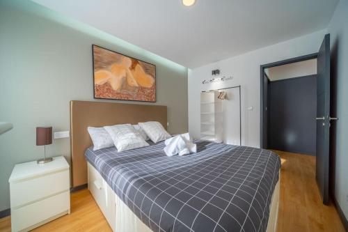 ein Schlafzimmer mit einem Bett mit einer blau karierten Decke in der Unterkunft Ofir Dream House in Fão