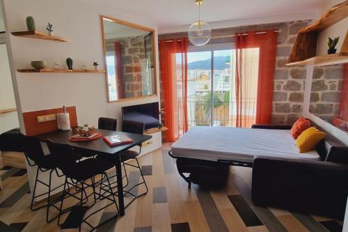 une chambre avec un lit et une table et une salle à manger dans l'établissement Magnifique appartement avec balcon vue mer à l'entrée d'Ajaccio, à Ajaccio