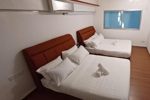 a bedroom with two beds with white sheets and a window at SY Staycation - Studio in Bayan Lepas