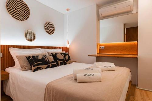 a bedroom with two beds and a mirror on the wall at Condessa I by Innkeeper in Lisbon