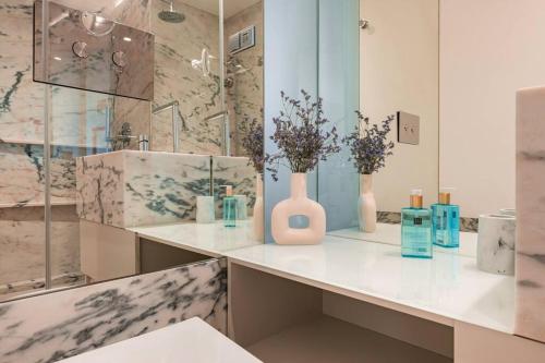 a bathroom with a counter with vases and flowers on it at Condessa I by Innkeeper in Lisbon