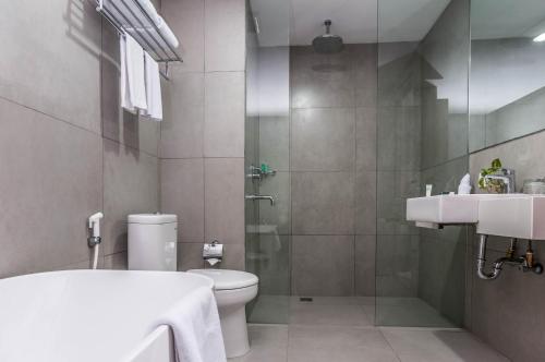 a bathroom with a toilet and a sink and a shower at KHAS Makassar Hotel in Makassar