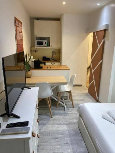 Cette chambre comprend un lit et une cuisine avec un bureau. dans l'établissement STUDIO LE TERRACOTTA - topbnb Dijon, à Dijon