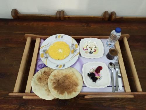 a tray of food with pancakes and other foods on it at Al-Manara Hostel Siwa Oasis in Siwa