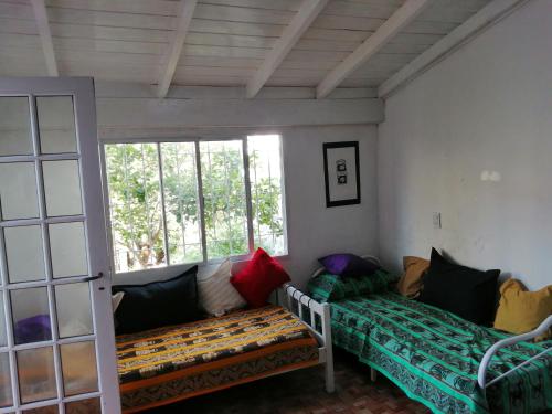 sala de estar con sofá y ventana en La Casita de Mogotes en Mar del Plata