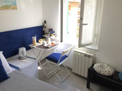 Habitación con escritorio, cama, mesa y silla. en Il Bordone - affittacamere a Manarola, Cinque Terre, en Manarola