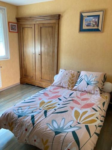 1 dormitorio con 1 cama con un edredón colorido en Chambre double 2, en Ruaudin