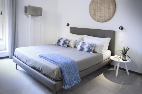 a bedroom with a large bed with blue and white pillows at Il Bordone - affittacamere a Manarola, Cinque Terre in Manarola