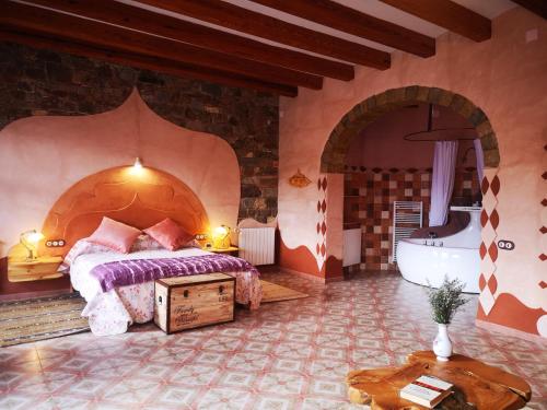 a bedroom with a bed and a tub in a room at Posada Del Río Carbo in Villahermosa del Río
