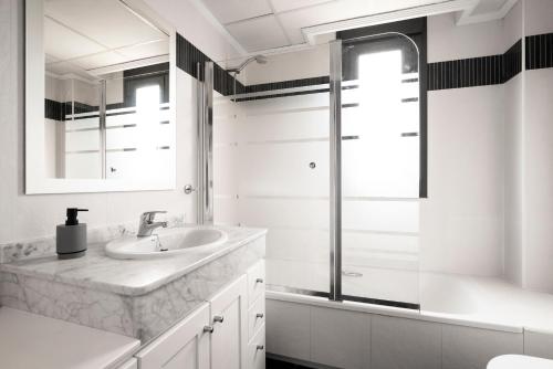 y baño blanco con lavabo y ducha. en EnjoyGranada EMIR 4C + Parking, en Granada