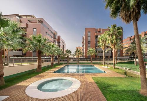uma piscina com palmeiras e edifícios em EnjoyGranada EMIR 4C + Parking em Granada