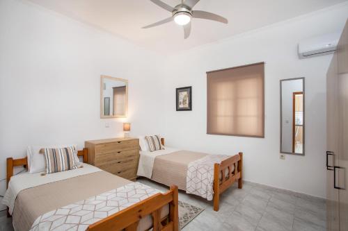 a bedroom with two beds and a ceiling fan at FALIRAKI CITRUS GARDEn in Faliraki