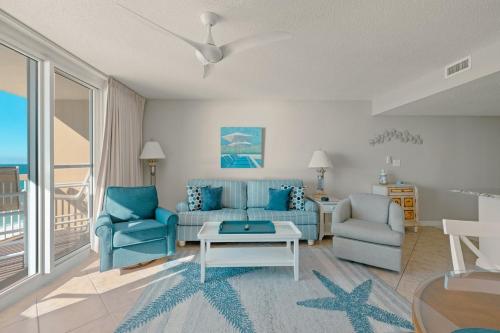 een woonkamer met een bank, 2 stoelen en een tafel bij Pelican Beach 0805 by Pelican Beach Management in Destin