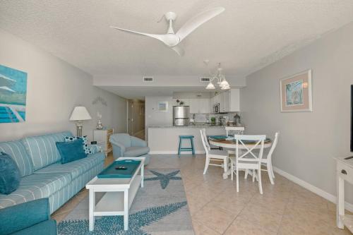 een woonkamer met een blauwe bank en een tafel bij Pelican Beach 0805 by Pelican Beach Management in Destin