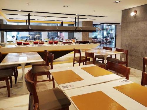 ein Restaurant mit Tischen und Stühlen und eine Bar in der Unterkunft Flat Particular Hotel Lets Idea - SEM CAFÉ in Brasilia
