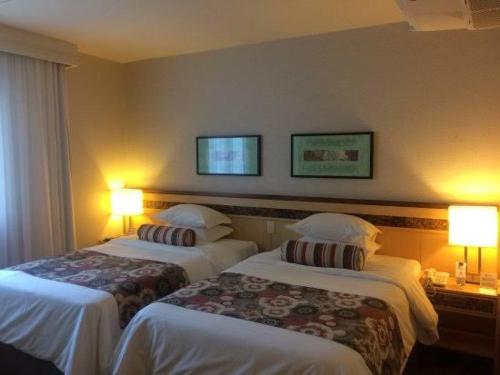 zwei Betten in einem Hotelzimmer mit zwei Lampen in der Unterkunft Flat Particular Hotel Lets Idea - SEM CAFÉ in Brasilia