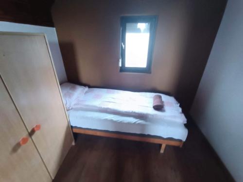 a small bed in a small room with a window at Tassi Halászcsárda - Sügér ház in Tass