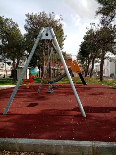 a swing set in a park with a playground at MAGNA GRECIA SEA HOME in Torre Canne
